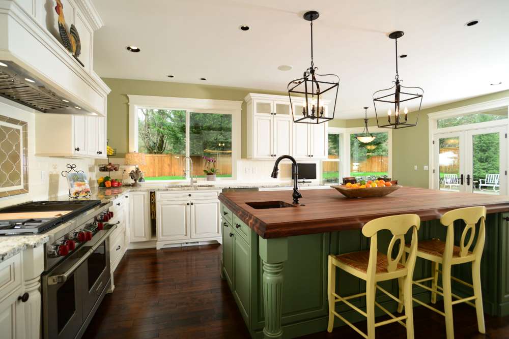 white kitchen cabinets with green island