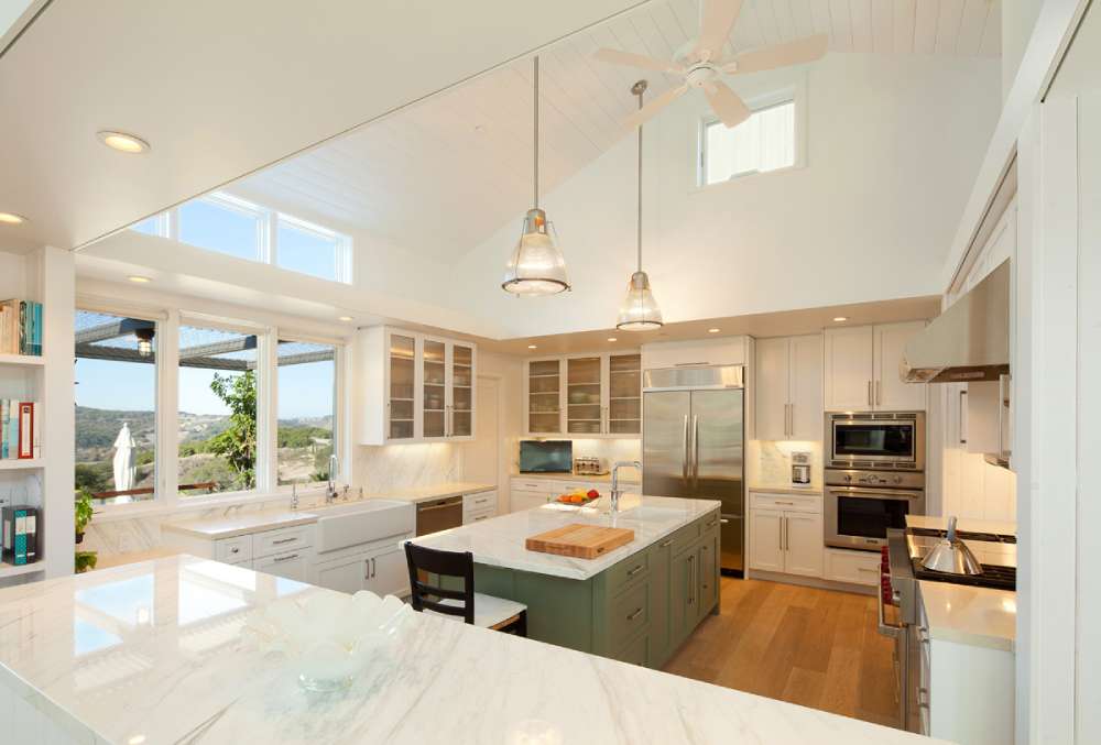 white kitchen cabinets with green island